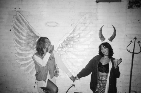 a magazines style director emma joffrion and photo editor maggie harris pose in front of a mural at 157 lounge. // photo by ?
